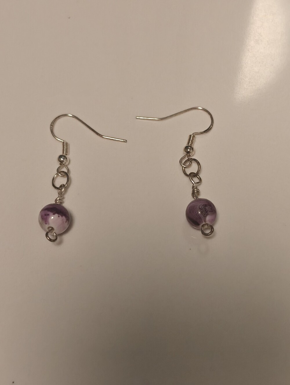 Silver tone Dangle earrings featuring swirled purple beads